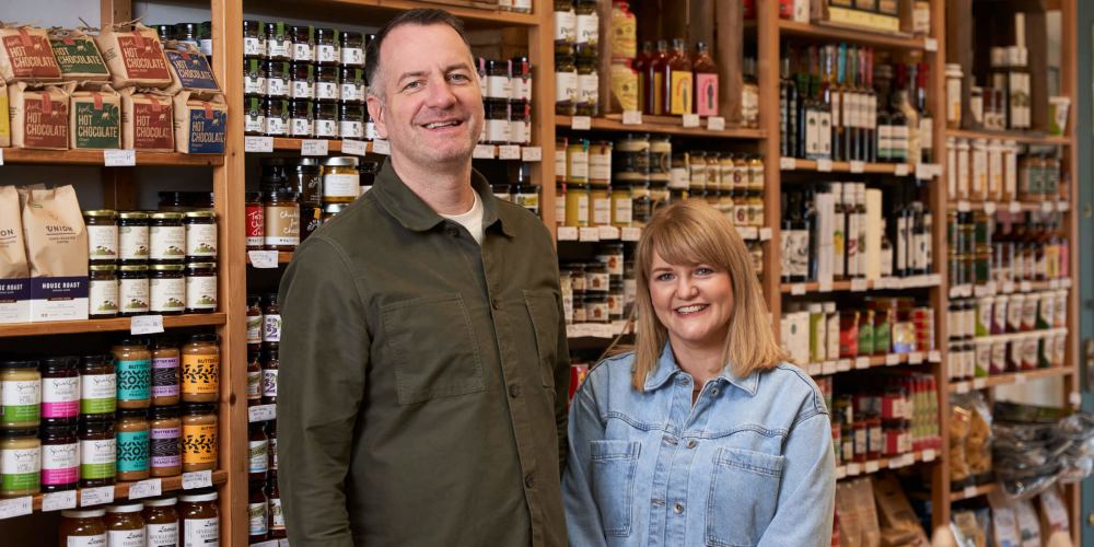Chris and Lynsey stand in their shop in front of their produce
