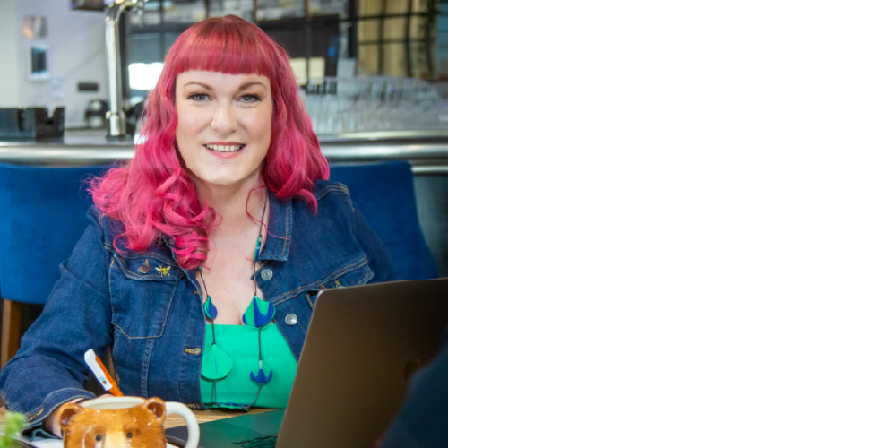 A woman with pink hair, wearing a denim jacket