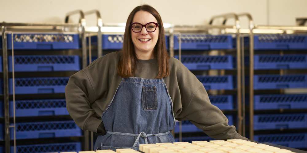 Jolene Roberts, FreeAgent customer and founder of award-winning natural cosmetics brand (and online retailer) Òir Soap, smiles in front of some of her products.
