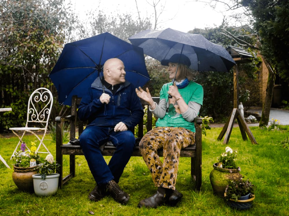 A woman sitting on a beanbag, while paper invoices flow into her computer.