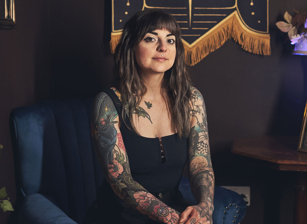Poppy Luna, Edinburgh-based tattoo artist sitting in her studio, Astra Lines.