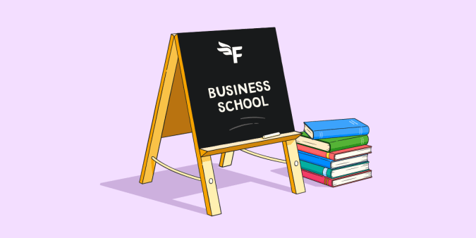 Pile of books and blackboard with 'business school' written on it